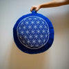 Ce coussin de yoga rond , appelé "Zafu" est fabriqué en coton bleu imprimé d'une Fleur de Vie, il est déhoussable et doté d'une poignée pour le transporter facilement.