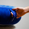Ce coussin de yoga zafu bleu, imprimé d'une  fleur de vie  est doté d'une poignée pour le transporter facilement